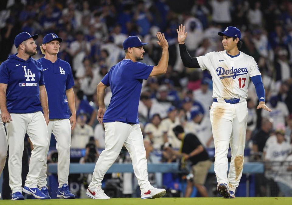 　レッズに勝利し、チームメートとタッチを交わすドジャース・大谷（右端）＝共同