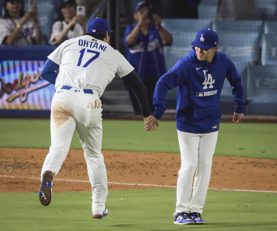 　レッズに勝利し、山本（右）とタッチを交わすドジャース・大谷（共同）