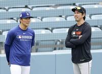 　３月、山本（左）と言葉を交わす前田（提供・共同通信社）