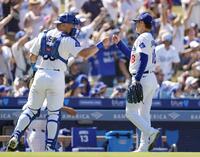 　ロッキーズ戦の７回を投げ終え、捕手とタッチを交わすドジャース・山本（共同）