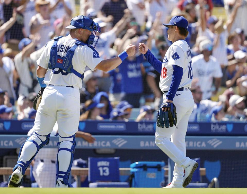 　ロッキーズ戦の７回を投げ終え、捕手とタッチを交わすドジャース・山本（共同）