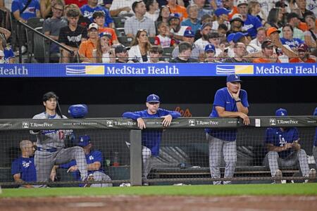 　オリオールズ戦の９回、ベンチで試合を見つめる大谷（手前左）ら。この後ドジャースはサヨナラ負けし、４連敗となった（共同）