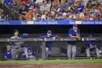 　オリオールズ戦の９回、ベンチで試合を見つめる大谷（手前左）ら。この後ドジャースはサヨナラ負けし、４連敗となった（共同）