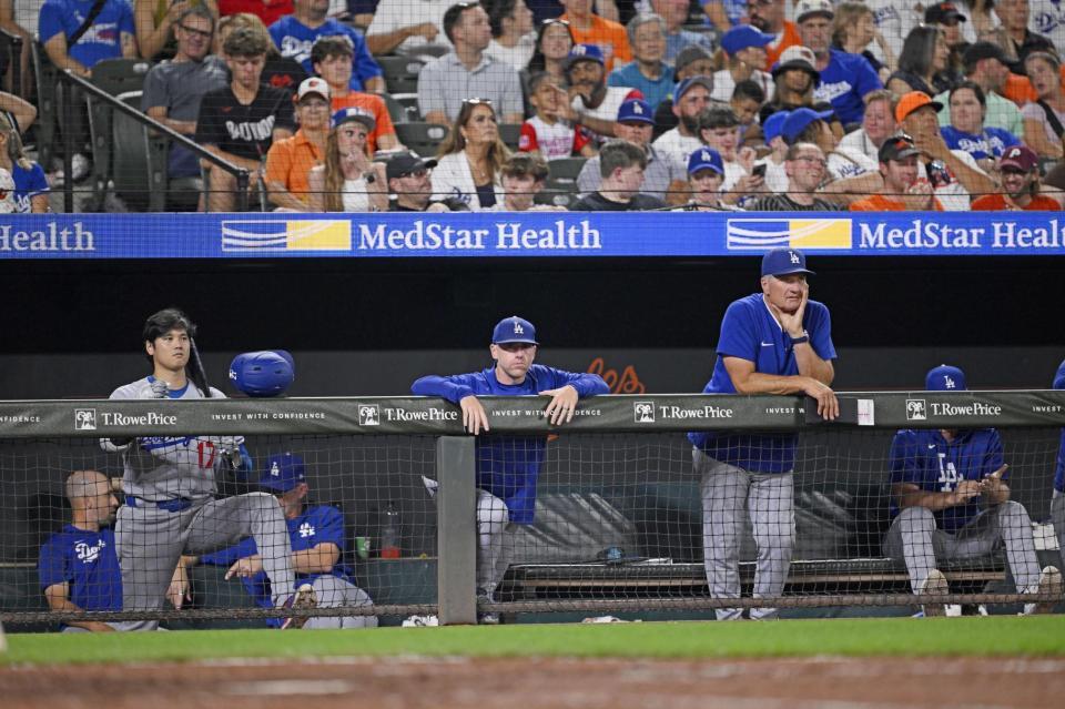 　オリオールズ戦の９回、ベンチで試合を見つめる大谷（手前左）ら。この後ドジャースはサヨナラ負けし、４連敗となった（共同）