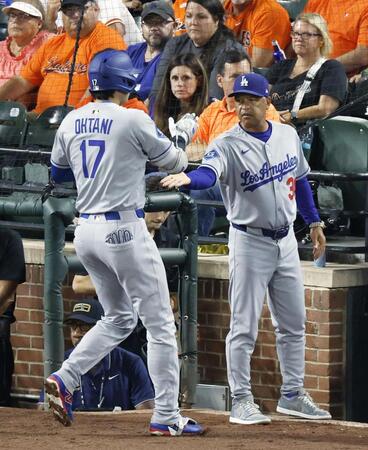 　オリオールズ戦の３回、遊ゴロで打点を挙げ、ベンチに戻りロバーツ監督（右）に迎えられるドジャース・大谷（共同）