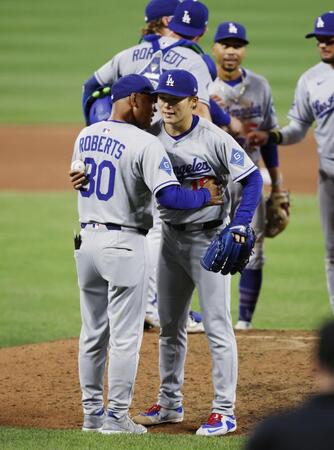 　オリオールズ戦の９回、無安打無得点試合まであと１人の場面で本塁打を浴び、ロバーツ監督（手前左）にハグされ降板するドジャース・山本（共同）