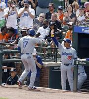 　オリオールズ戦の１回、47号ソロを放ちロバーツ監督（右）に迎えられるドジャース・大谷（共同）