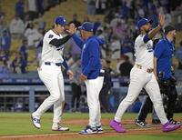 　勝利し、ロバーツ監督とタッチを交わす大谷（左端）＝共同