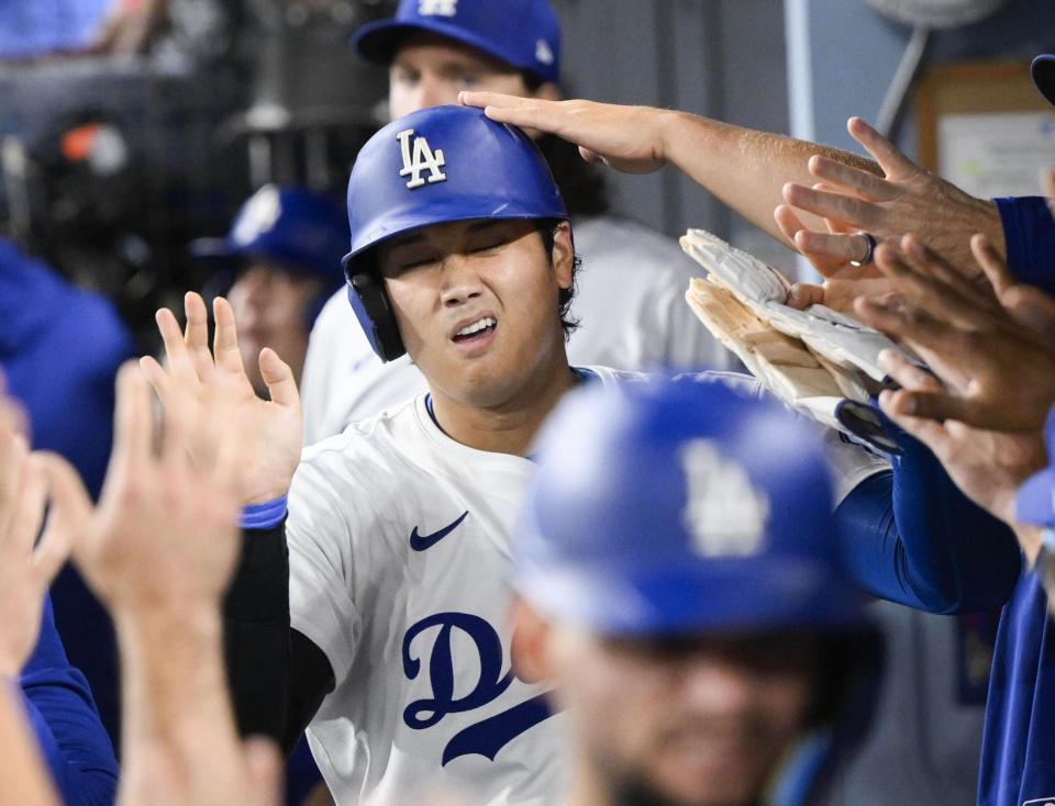 　７回、ベッツの勝ち越し２点打で生還し、ベンチで迎えられる大谷（共同）