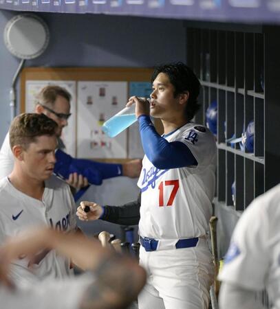 　ベンチで飲み物を口にする大谷（共同）