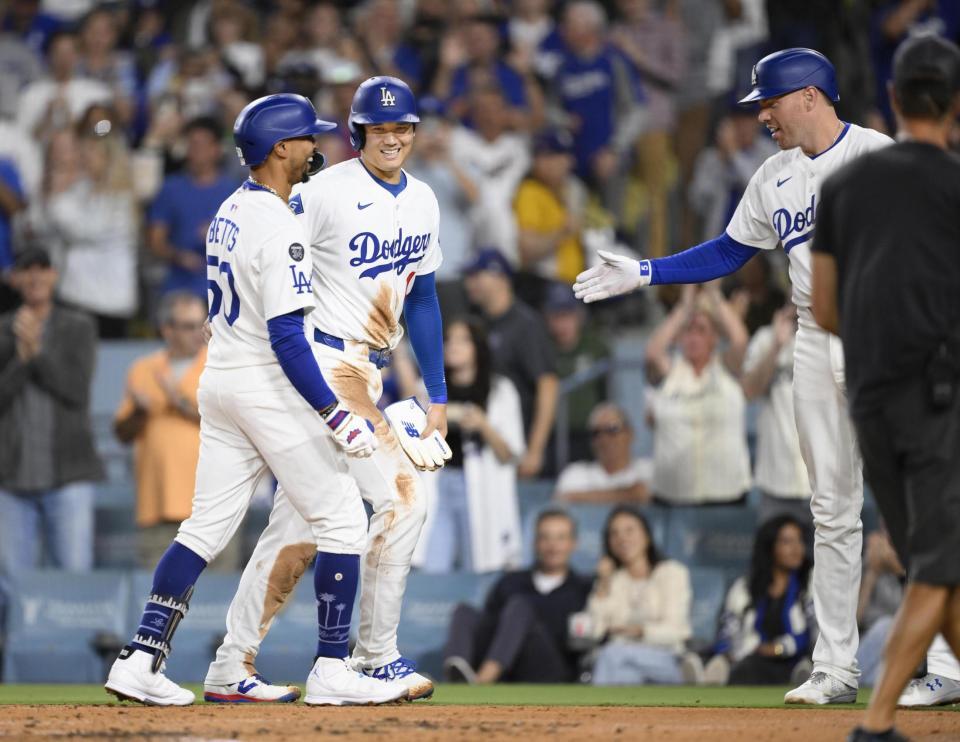 　３回、２ランを放ったベッツ（左）を迎える、二走大谷（中央）と次打者フリーマン（共同）