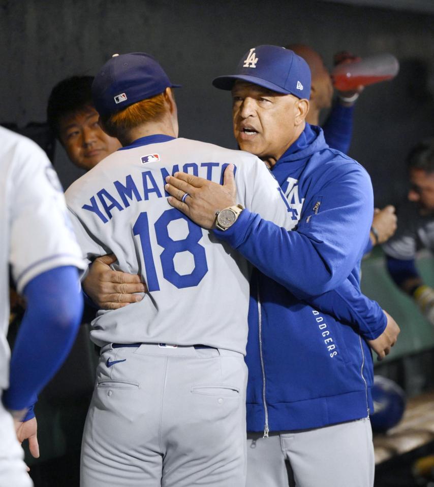 　ジャイアンツ戦の７回を投げ終え、ロバーツ監督（右）にねぎらわれる山本