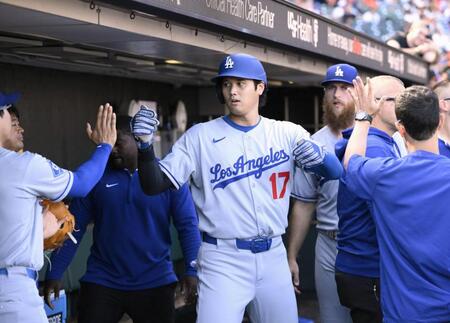 　９回、後続の適時打で生還し、ベンチで迎えられる大谷（共同）
