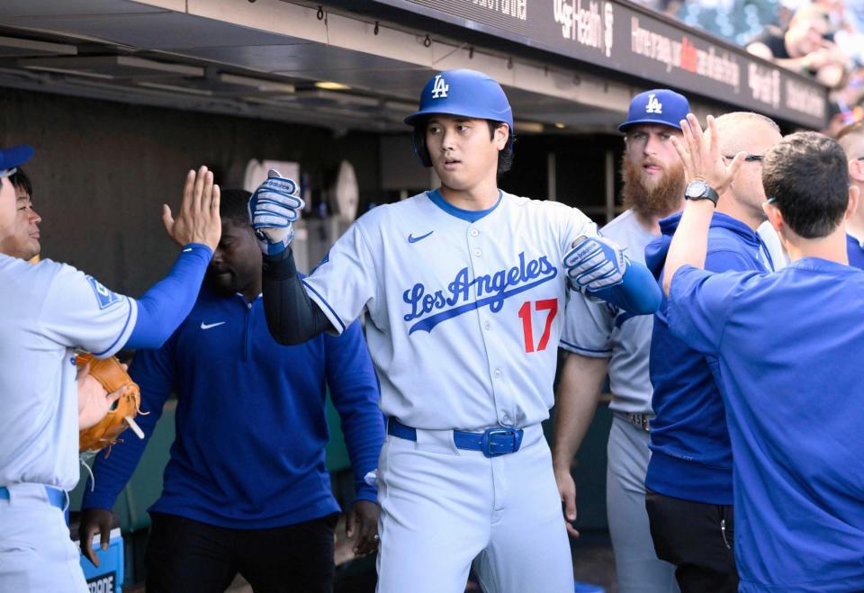 　９回、後続の適時打で生還し、ベンチで迎えられるドジャース・大谷（共同）