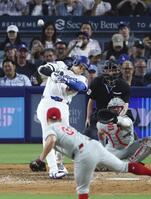 　フィリーズ戦の８回、50号ソロを放つドジャース・大谷翔平。メジャー史上６人目となる２年連続のシーズン50本塁打に到達した（共同）