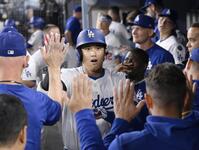 　フィリーズ戦の８回、50号ソロを放ち、祝福されるドジャース・大谷翔平。メジャー史上６人目となる２年連続のシーズン50本塁打に到達した（共同）