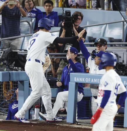　ジャイアンツ戦の６回、フリーマンの適時打で生還しロバーツ監督（右）に迎えられるドジャース・大谷（共同）