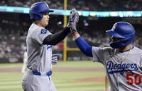 　１回、ベッツ（右）の犠飛で生還しタッチを交わす大谷（共同）