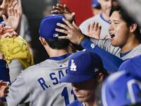 　７回に登板し、三者凡退に抑えベンチの大谷（右）らに迎えられる佐々木（共同）