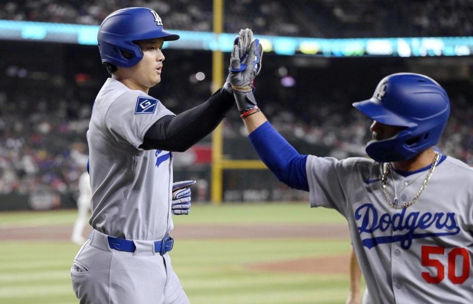 　１回、ベッツ（右）の犠飛で生還しタッチを交わす大谷（共同）