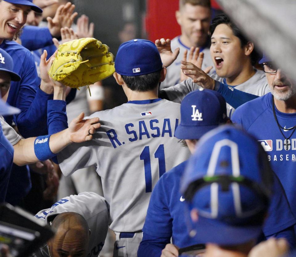 　７回を三者凡退に抑え、ベンチで迎えられる佐々木（11）＝共同