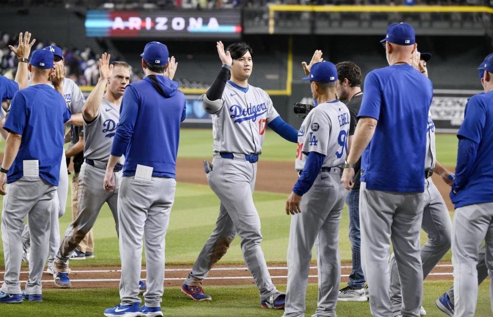 　勝利し、チームメートとタッチを交わす大谷（中央）＝共同