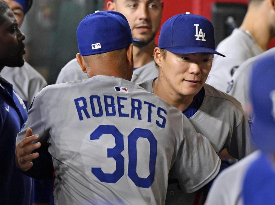 　ダイヤモンドバックス戦に先発し、６回を無失点で投げ終えベンチでロバーツ監督（30）とハグする山本（共同）