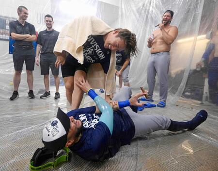 　ナ・リーグ西地区４連覇を決め、シャンパンファイトでロハス（下）とじゃれ合うドジャース・山本（共同）