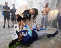 　ナ・リーグ西地区４連覇を決め、シャンパンファイトでロハス（下）とじゃれ合うドジャース・山本（共同）