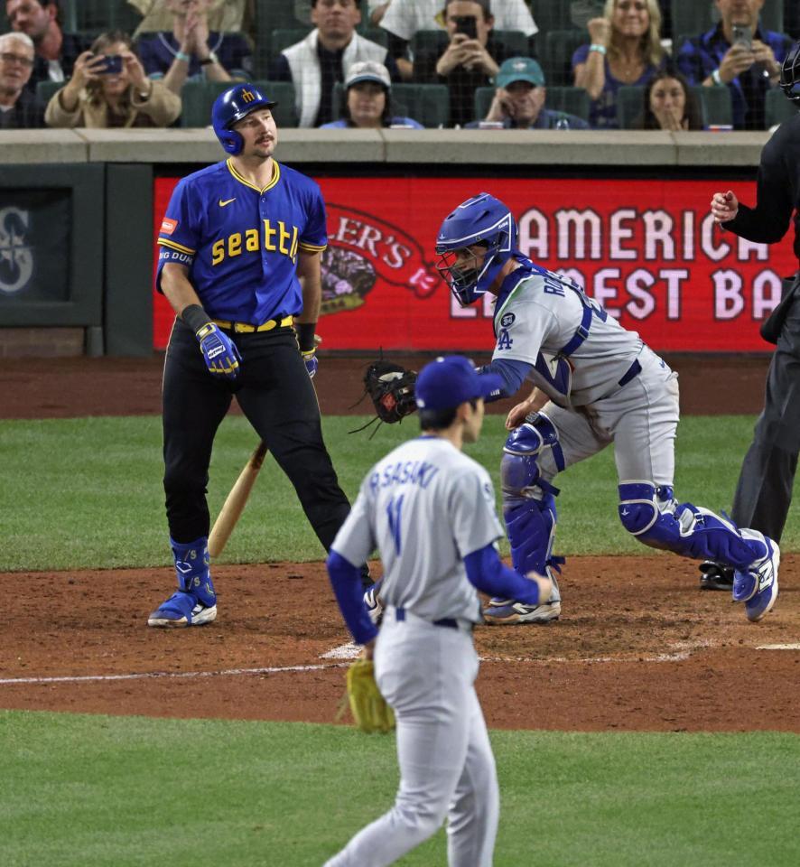 　７回、マリナーズのローリーを空振り三振に仕留めた佐々木（手前）＝共同