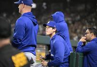 　マリナーズ戦の先発を外れ、ベンチで試合を見つめる大谷（中央）＝共同