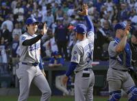 　レギュラーシーズン最終戦を勝利で終え、ロバーツ監督（中央）とタッチを交わすドジャース・大谷（共同）