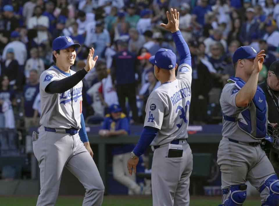 　レギュラーシーズン最終戦を勝利で終え、ロバーツ監督（中央）とタッチを交わすドジャース・大谷（共同）