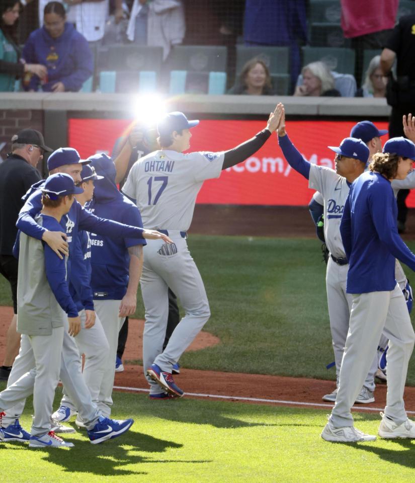 　レギュラーシーズン最終戦を勝利で終え、ロバーツ監督とタッチを交わすドジャース・大谷（17）＝共同