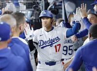 　ワイルドカードシリーズ第１戦のレッズ戦で、６回にこの試合２本塁打目となる２ランを放ち、ベンチでタッチを交わす大谷（共同）