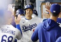 　レッズ戦の３回、チームメートとタッチを交わす進塁打を放った大谷（共同）