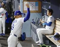 　レッズ戦の５回のマウンドに上がる前、ベンチで調整する山本。右は大谷（共同）