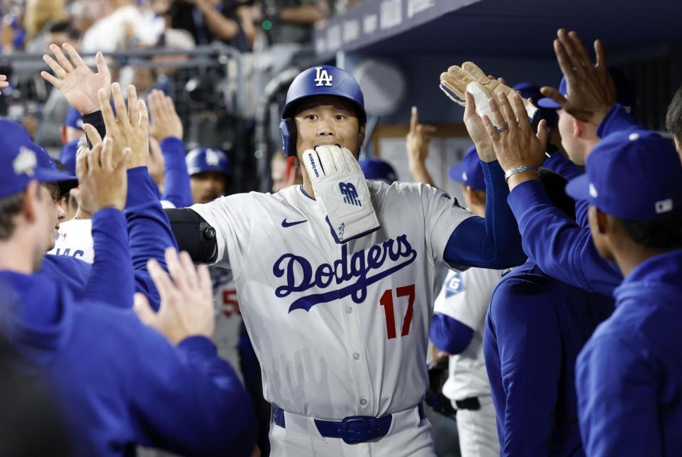 　レッズ戦の６回、後続の適時打で生還しチームメートに迎えられる大谷（共同）