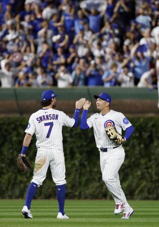 　パドレスに勝利し地区シリーズ進出を決め、スワンソン（左）とタッチを交わすカブス・鈴木（共同）