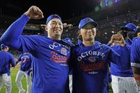 　パドレスに勝利し地区シリーズ進出を決め、今永（右）とポーズをとるカブス・鈴木（共同）