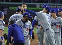 　フィリーズに勝利し、初セーブを挙げた佐々木（左奥）を迎える大谷（共同）