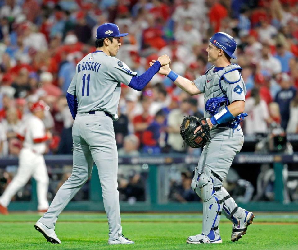 　捕手スミスとタッチを交わす佐々木（共同）