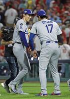　フィリーズに勝利し、大谷（右）に迎えられる佐々木（共同）