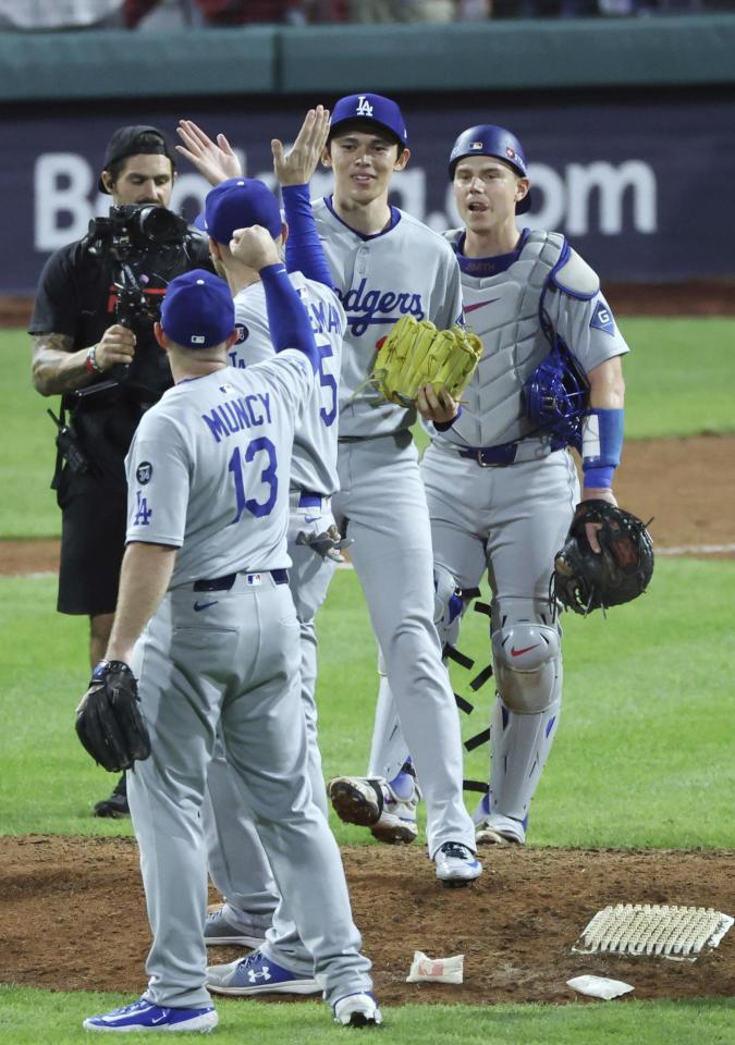 　フィリーズに勝利しチームメートとタッチを交わす佐々木（右から２人目）＝（共同