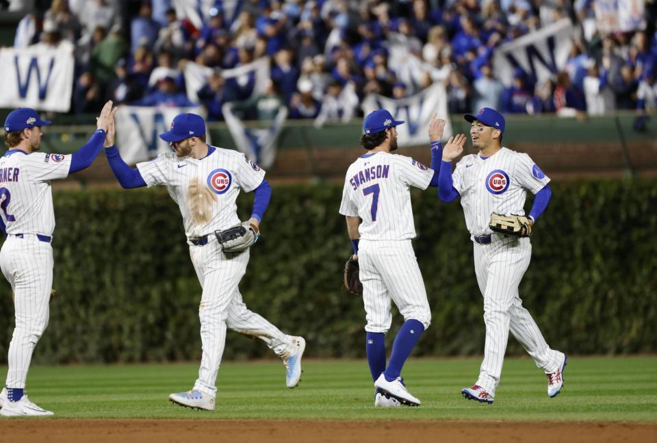 　ブルワーズに勝利し、タッチを交わす鈴木（右端）＝共同