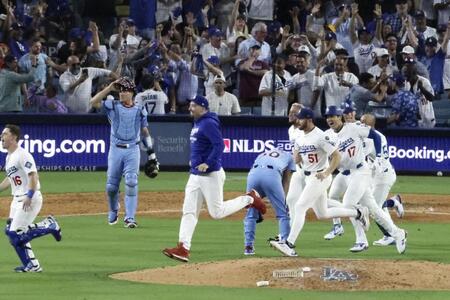 　勝利し大喜びのドジャースナイン。中央でがっくりと肩を落とすのは、ゴロを捕り損ね、本塁へ悪送球して三走にサヨナラの生還を許したカーカリング（共同）