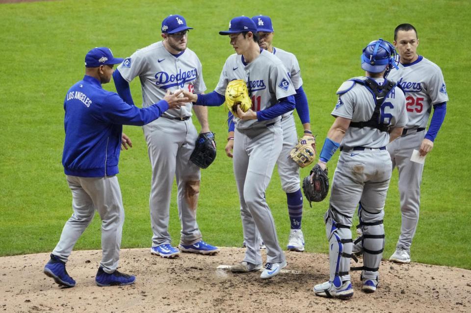 　ブルワーズ戦の９回、ロバーツ監督（左端）にボールを渡すドジャース・佐々木（イマジンイメージズ・ロイター＝共同）