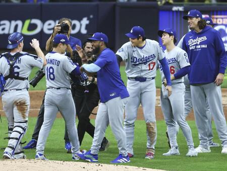 　ブルワーズ戦で完投勝利を挙げ、大谷（17）に迎えられるドジャース・山本（18）＝共同