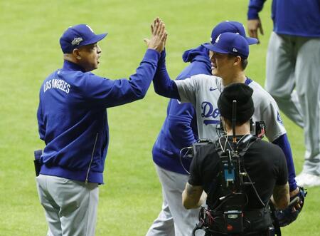 　ブルワーズ戦で完投勝利を挙げ、ロバーツ監督（左）に迎えられるドジャース・山本（共同）