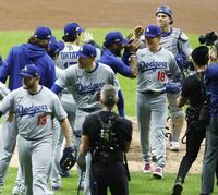 　ブルワーズ戦で完投勝利を挙げ、大谷（左奥）らに迎えられるドジャース・山本（18）＝共同